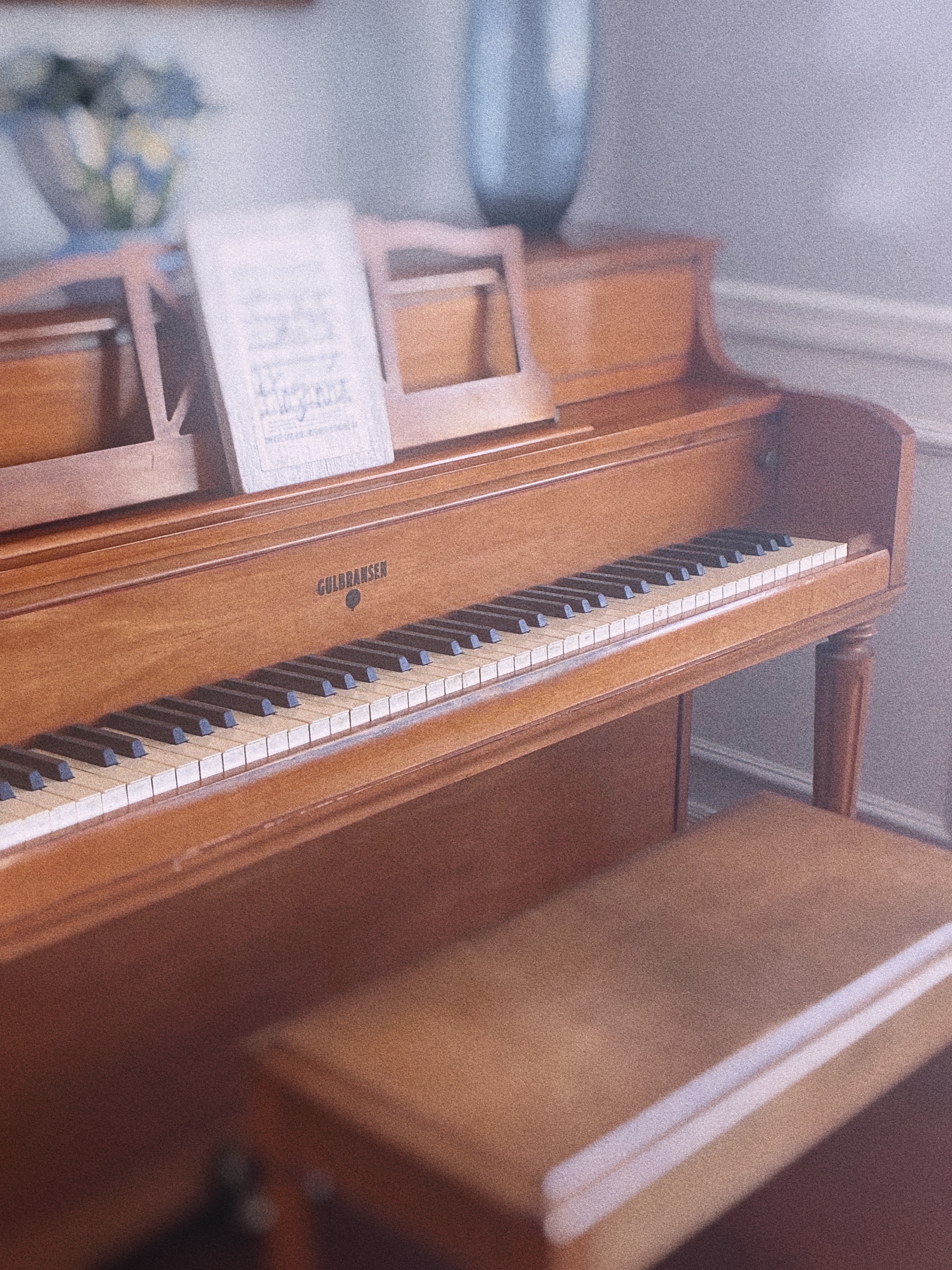 A vintage piano with sheet music open on the stand